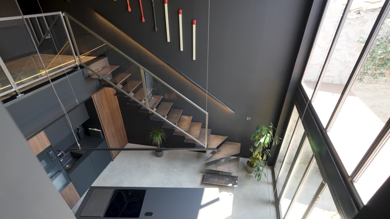 A rendered 3D model of a modernistic architectural interior featuring sleek stairways and expansive glass windows. Stylish minimalism, open spaces, and natural light, creating a futuristic aesthetic.