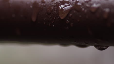 water moisture dripping on metal pipe, extreme closeup