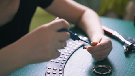 trabajador cualificado atornilla pernos en accesorios metálicos para la bolsa