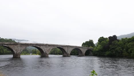 puente de piedra que atraviesa un río tranquilo