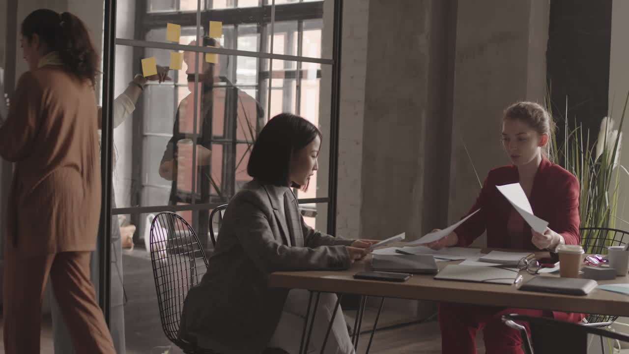 Female Managers Reading Documents in Office