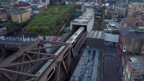 drone shot london overground tube travelling through commuter town