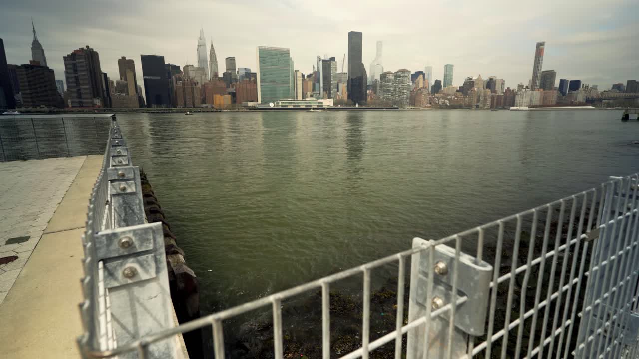 Overskyet dag i NYC med utsikt over East River mot Midtown Manhattan fra Queens Piers