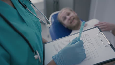 detail of an empty medical report in the hands of an unrecognizable doctor