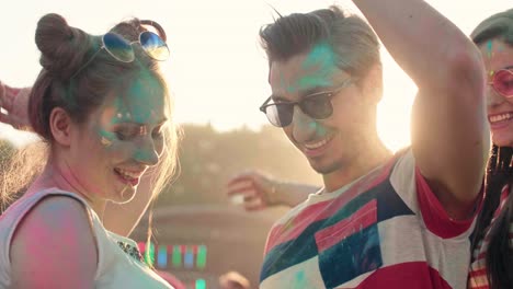 pareja en colores de holi bailando entre brillantes rayos de sol