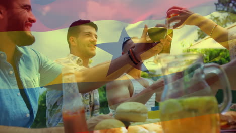 video compuesto de la bandera de ghana sobre diversos amigos brindando bebidas mientras almuerzan en el parque