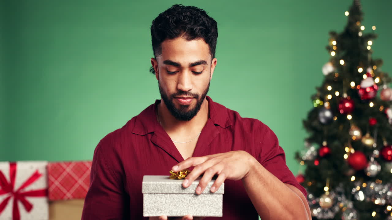 크리스마스 선물을 열고 있는 남자