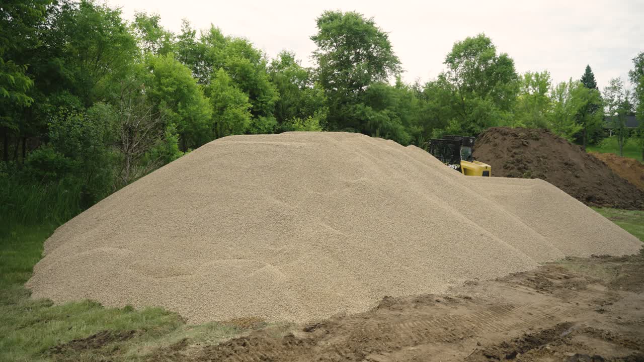 Gravel and dirt piles at home build site for pool backfill in Wisconsin