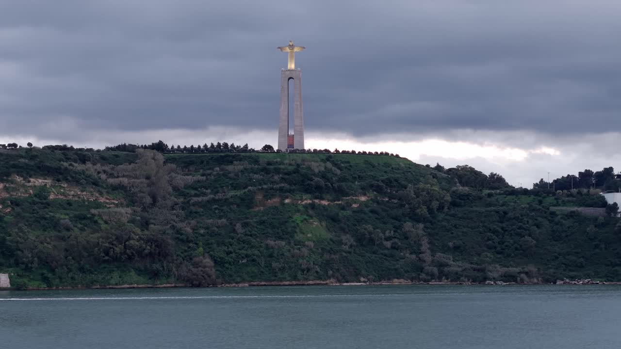 Lizbon'da, Tajo Nehri haliçinde gün batımında bulutlu gökyüzü altında İsa Kral Kutsal Alanı, havadan görünüm.