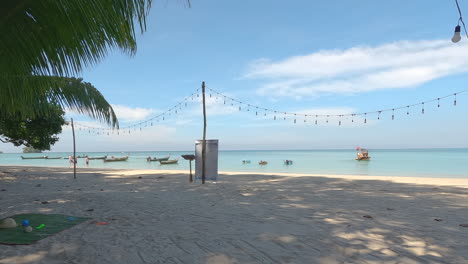 Time-lapse-of-the-Nai-Yang-in-Thailand-Phuket-beach-with-people,-palm-and-longtail-boats