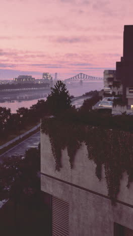 vibrant sunset reflects on calm river with modern architecture nearby