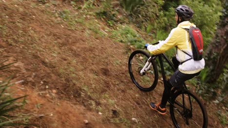 motociclista de montaña masculino montando en el bosque