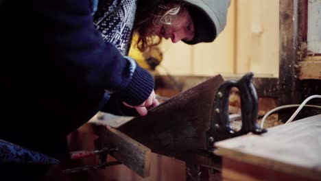 the man is tidying up the saw's teeth, an essential tool required for constructing the diy hot tub - static shot