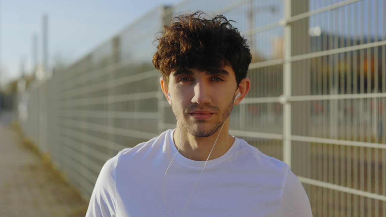 Young Man Walking and Listening to Music