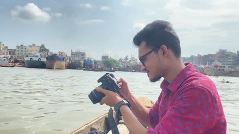 travel photographer taking photo middle of buriganga river on a boat in bangladesh