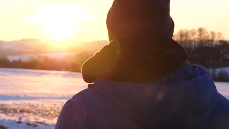 un hombre está protagonizando un maravilloso paisaje con una puesta de sol de hora dorada en un país de las maravillas del invierno