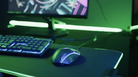 video of gaming computer and gaming equipment on desk with copy space on neon background