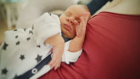 adorable newborn sleeping on mother's chest