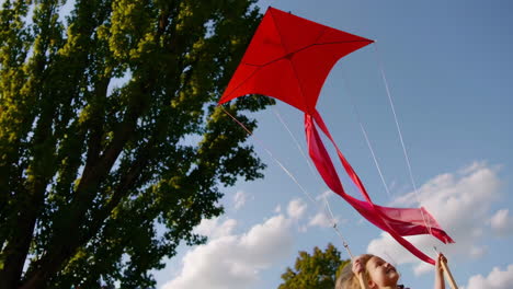 girl flying a kite on a swing