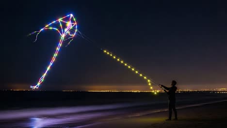a spectacular night scene of a colorful lighted kite soaring against the ocean horizon, illuminating the dark sky with vibrant patterns and slow moving waves
