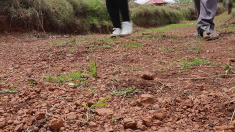 ángulo bajo de los pies de un grupo de personas caminando por un camino de tierra en áfrica