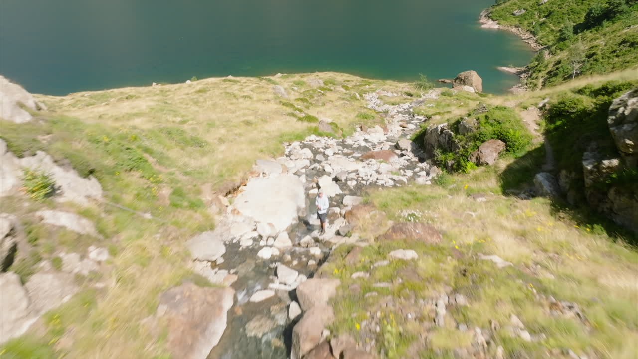 un excursionista cruzando un arroyo de montaña en las montañas francesas de los pirineos