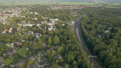 aerial of train tracks running next to a beautiful small town