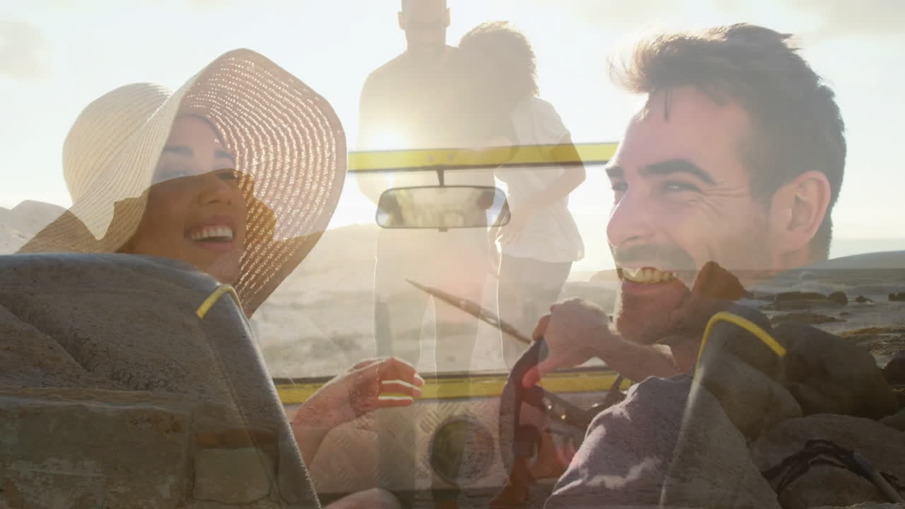 In car, smiling couple with animation overlay of couple walking on beach
