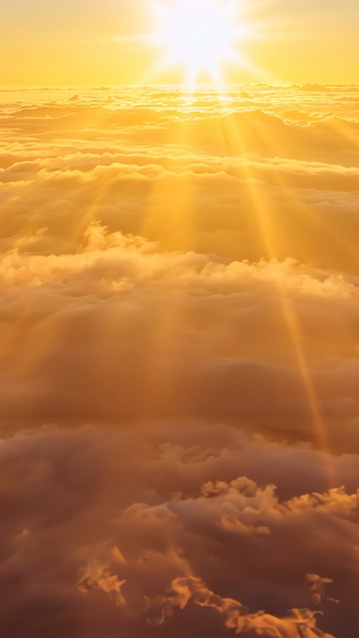 Vertical video: Ascending golden sun above shifting cloud layer at altitude, illuminating dawn sky