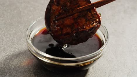 roasted eggplant in dark sauce with chopsticks