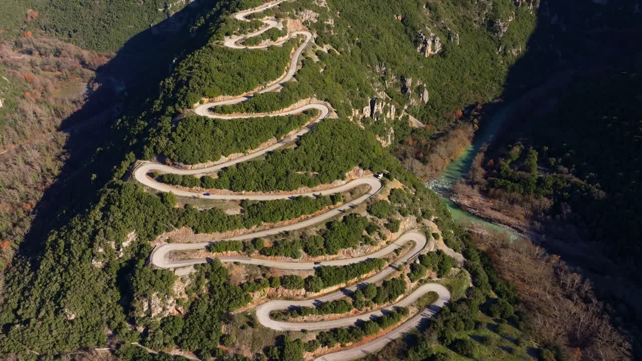Aerial capture of curved road through golden hills, Papigko Pass