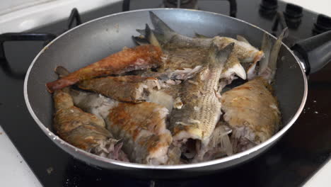 the fish is fried in a teflon pan for healthy lunch meal