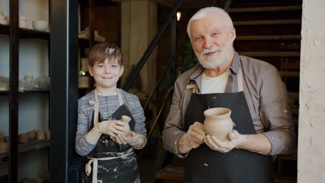 grandfather and grandson creating pottery in a studio