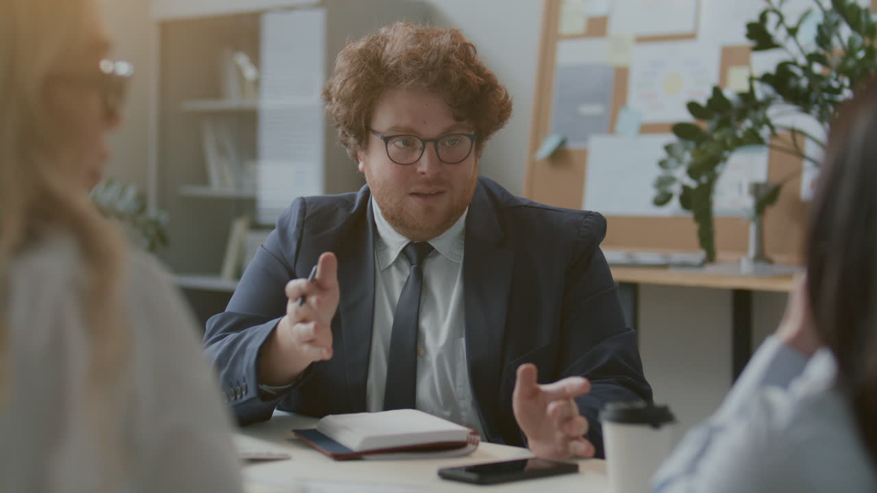 Businessman Presenting Ideas during Office Meeting with Team