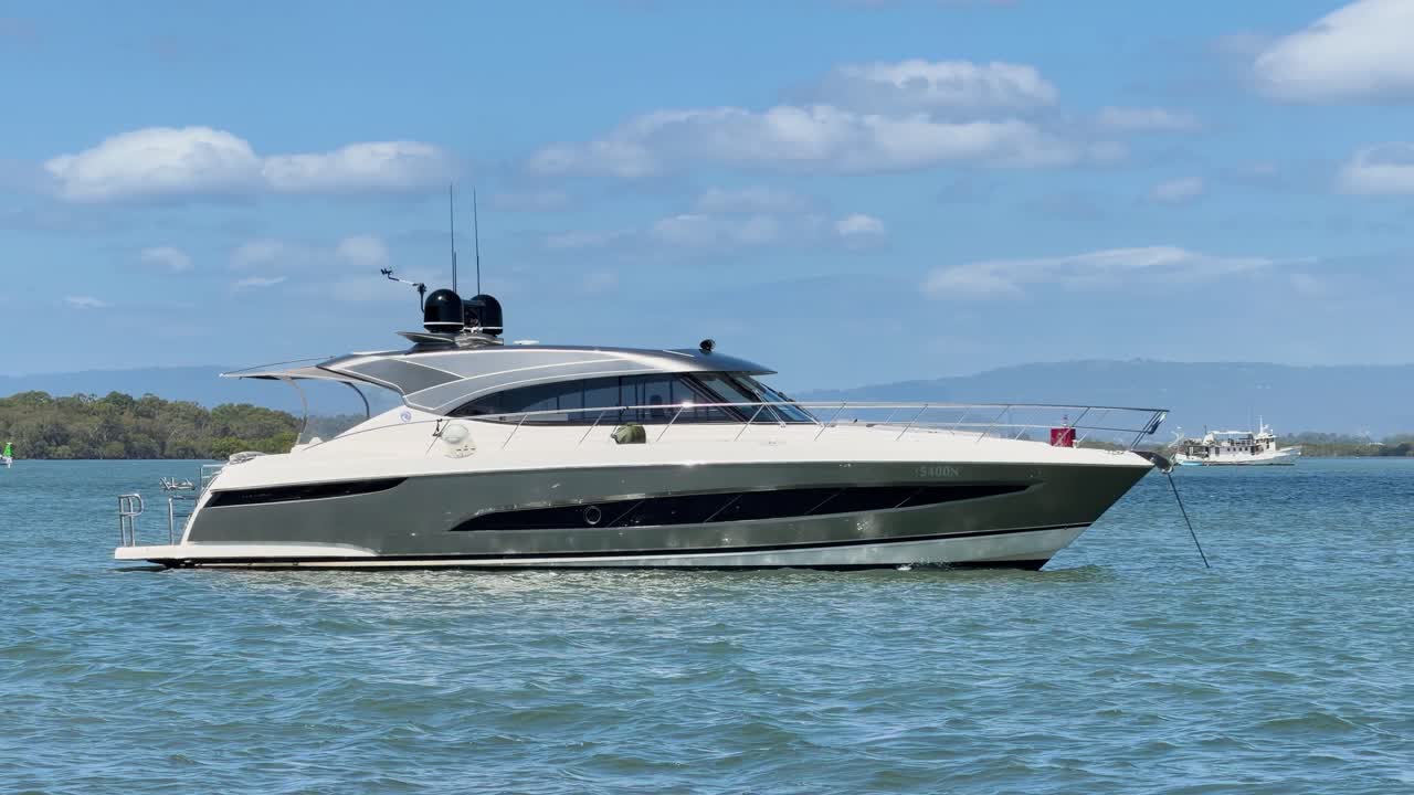Un moderno yacht elegante galleggia su acque blu calme sotto un cielo soleggiato e luminoso