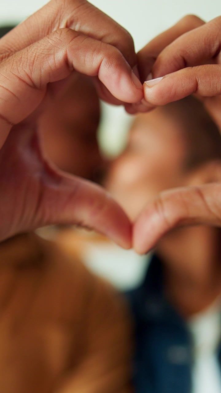 Pareja haciendo un corazón con las manos