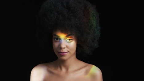 Primer-Plano-Retrato-Multicolor-Hermosa-Mujer-Afroamericana-Con-Afro-Disfrutando-De-Una-Piel-Suave-Y-Saludable-Que-Parece-Segura-Belleza-Natural-Luz-Colorida-Sobre-Fondo-Negro-Concepto-De-Cuidado-De-La-Piel