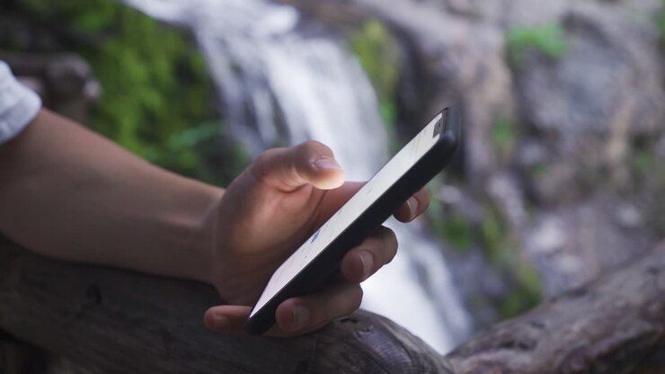 Guardare il telefono nella natura