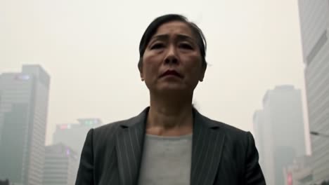 in a desolate urban landscape shrouded in haze, a determined woman steps forward, embodying resilience amidst climate change and environmental degradation challenges