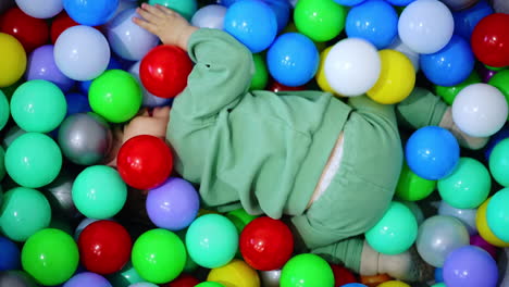 baby playing in a colorful ball pit