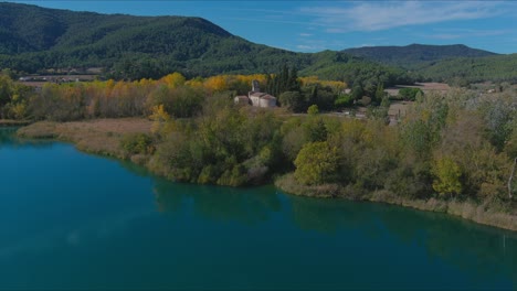 Aerial-view-of-Lake-Banyoles-and-Santa-Maria-de-Porqueres-Church,-Girona