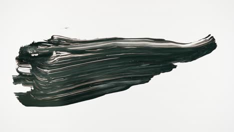 hand applying thick black substance in an abstract stroke
