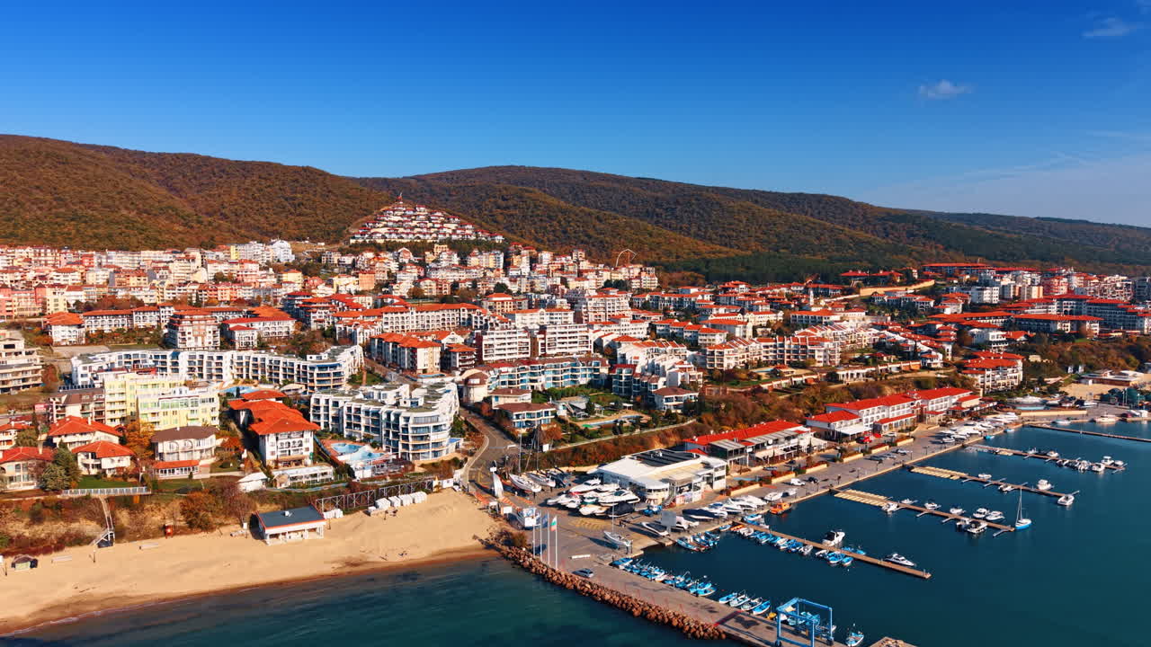 Kayalık kıyının yamacına inşa edilmiş, kırmızı çatılı çok katlı çok sayıda otel. Bulgaristan'daki Karadeniz kıyısındaki tatil kentinden uzaklaşıyor. Hava çekimi