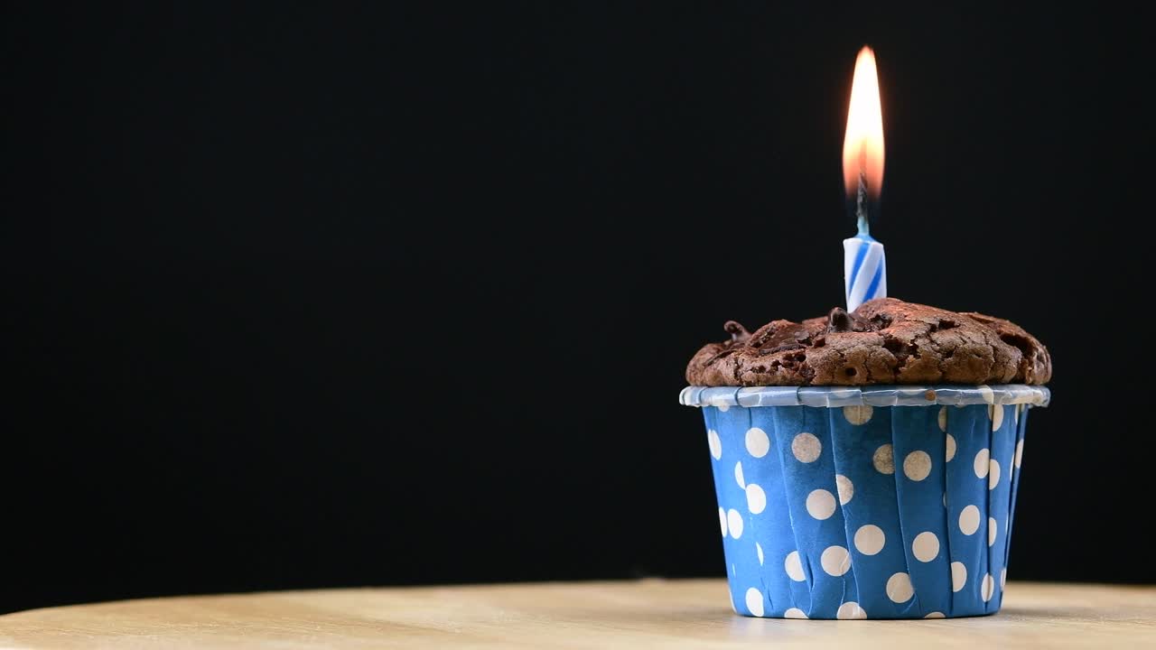fiesta de pasteles con vela en fondo azul cinemagraph bucle sin costuras.