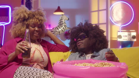 friends watching movie with popcorn and drinks in a retro-themed living room
