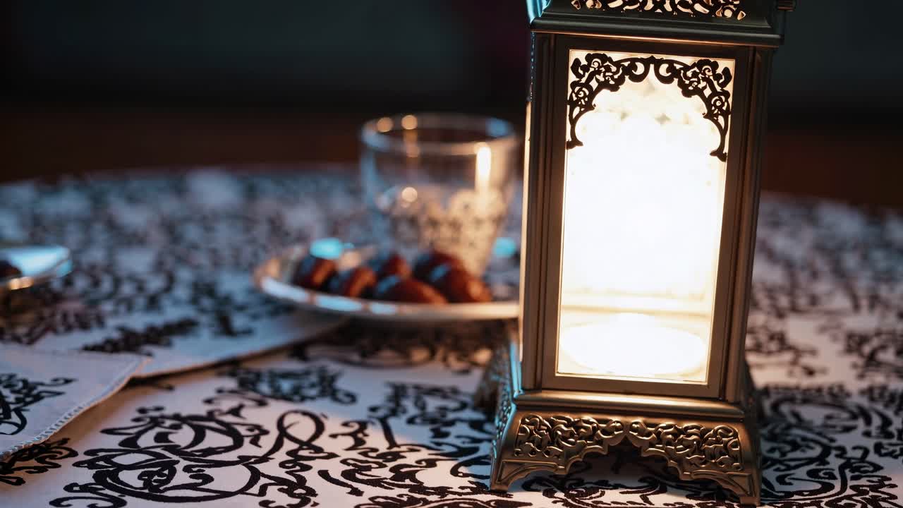 Ornate lantern glowing warmly near carefully arranged dates and water glass, representing peaceful Ramadan evening moment of tranquil iftar gathering
