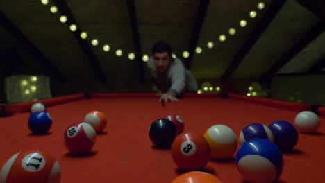 view of a man with cue stick playing billiards on a red table - selective focus