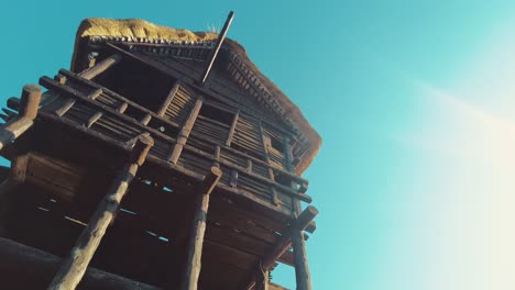 Prehistoric-primitive-old-wooden-hut-on-stilts-with-thatched-roof-low-angle