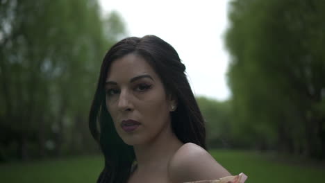 Portrait-of-an-attractive-latina-woman-with-black-wavy-hair-and-a-floral-dress-looking-in-camera,-close-up-shot