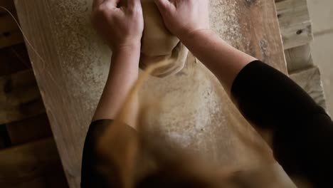 Top-Footage-Of-Female-Hands-With-Beautiful-Red-Manicure-Holding-Clay-And-Kneading-It-On-A-Worktop